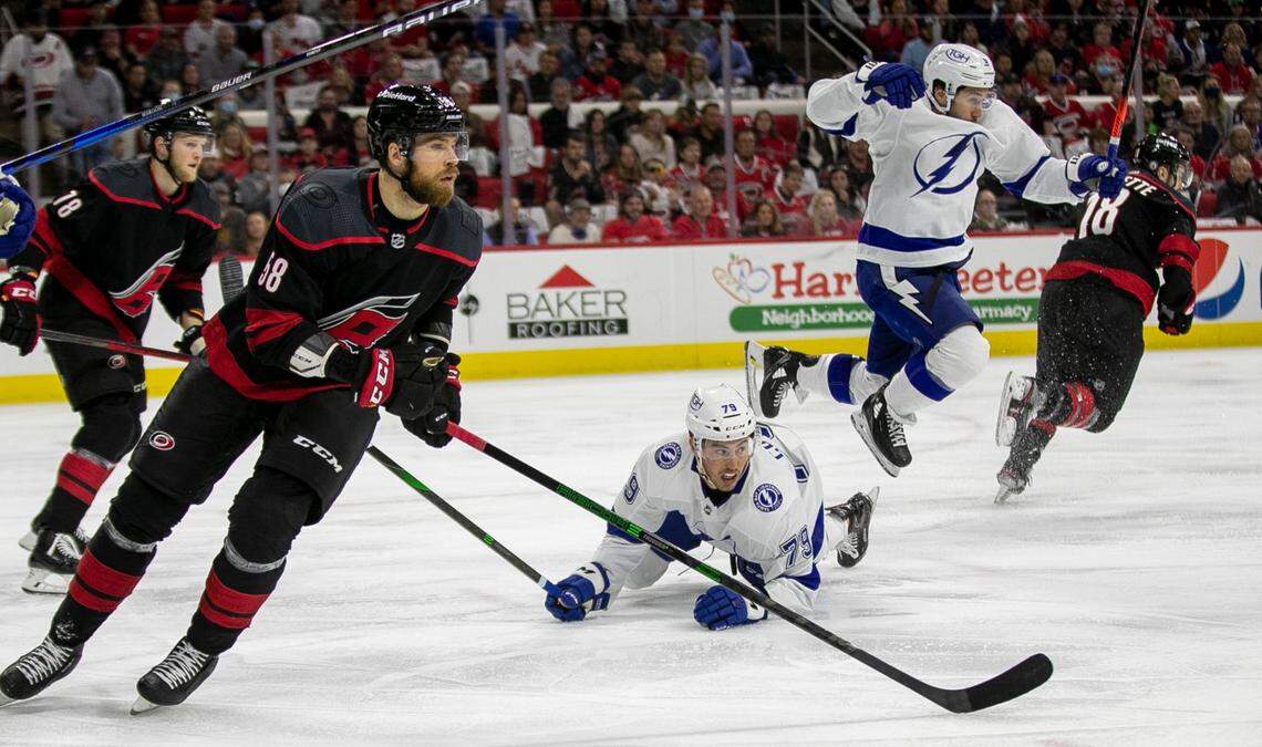 Tampa’s Tyler Johnson (9) hurdles over teammate Ross Colton (79) as they chase down the puck in the first period ahead of Carolina Hurricanes’ Jani Hakanpaa (58) during game one of their second round Stanley Cup series on Sunday, May 30, 2021 at PNC Arena in Raleigh, N.C.