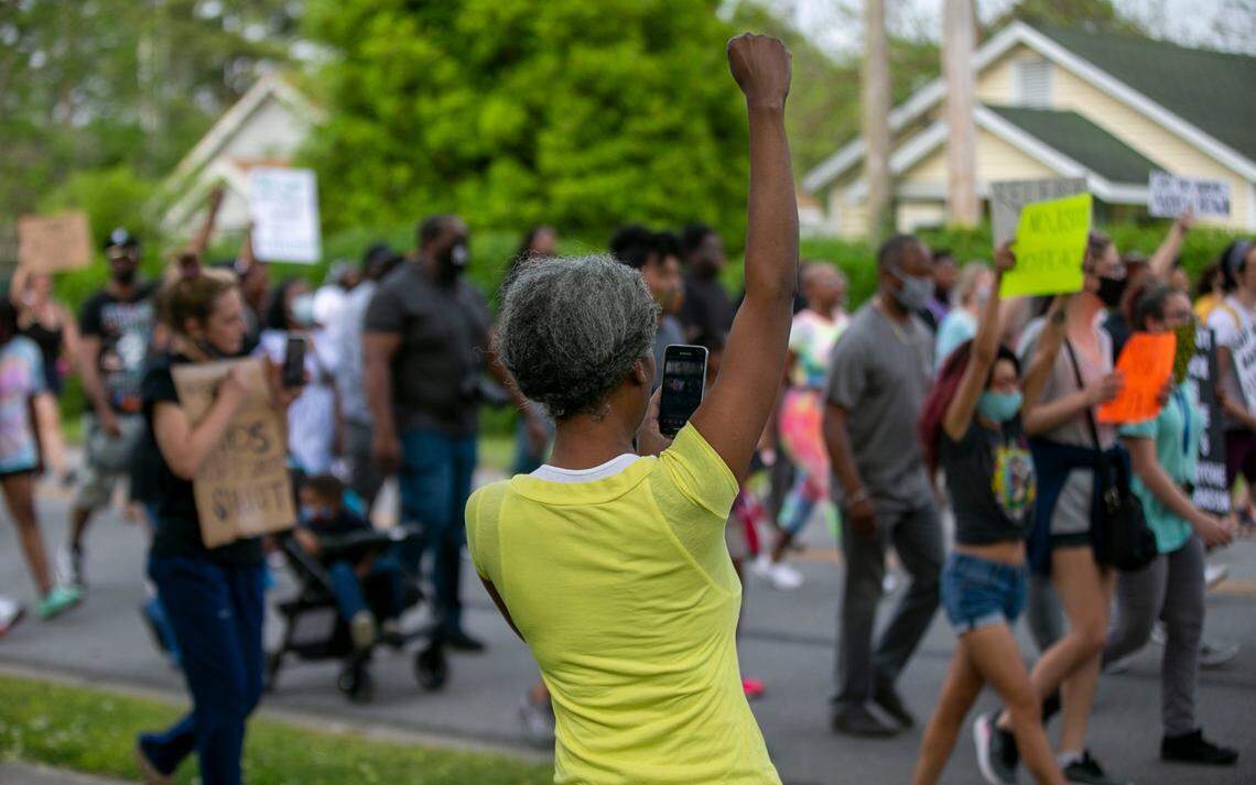 Sharon Kirby shows her solidarity with demonstrators as they march past her Roanoke Avenue home on Thursday, April 29, 2021 in Elizabeth City, N.C. This is the ninth day of demonstrations in the wake of Andrew Brown Jr.s death at the hands of Pasquotank County deputies