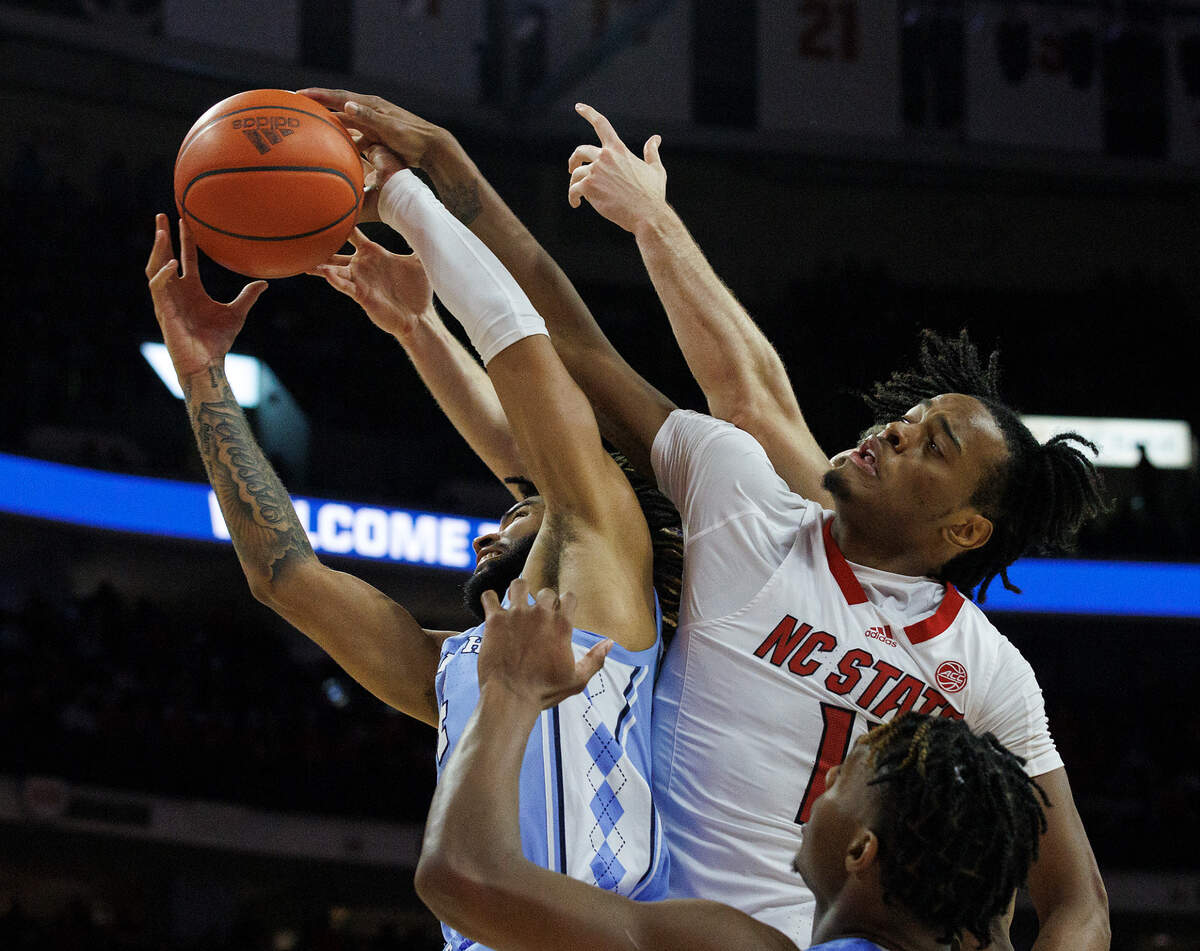 North Carolina’s RJ Davis pulls down a rebound away from N.C. State’s Dennis Parker Jr. during the second half of the Tar Heels’ 67-54 win at PNC Arena on Wednesday, Jan. 10, 2024, in Raleigh, N.C.