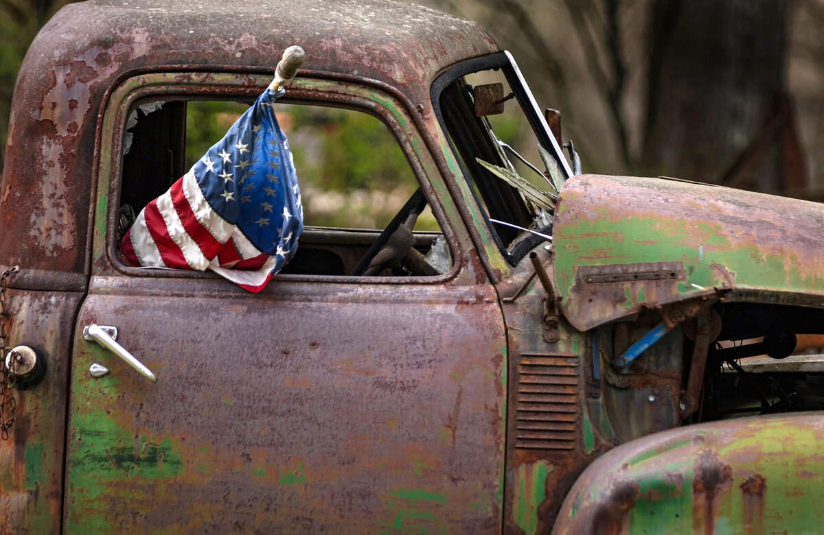 A tattered flag in a rusting truck on a rural road in Chatham County. An Elon University poll shows Gen Z optimism, cross‑age pride, preferred local America250 events, and views on presidents, democracy and the nation's future.