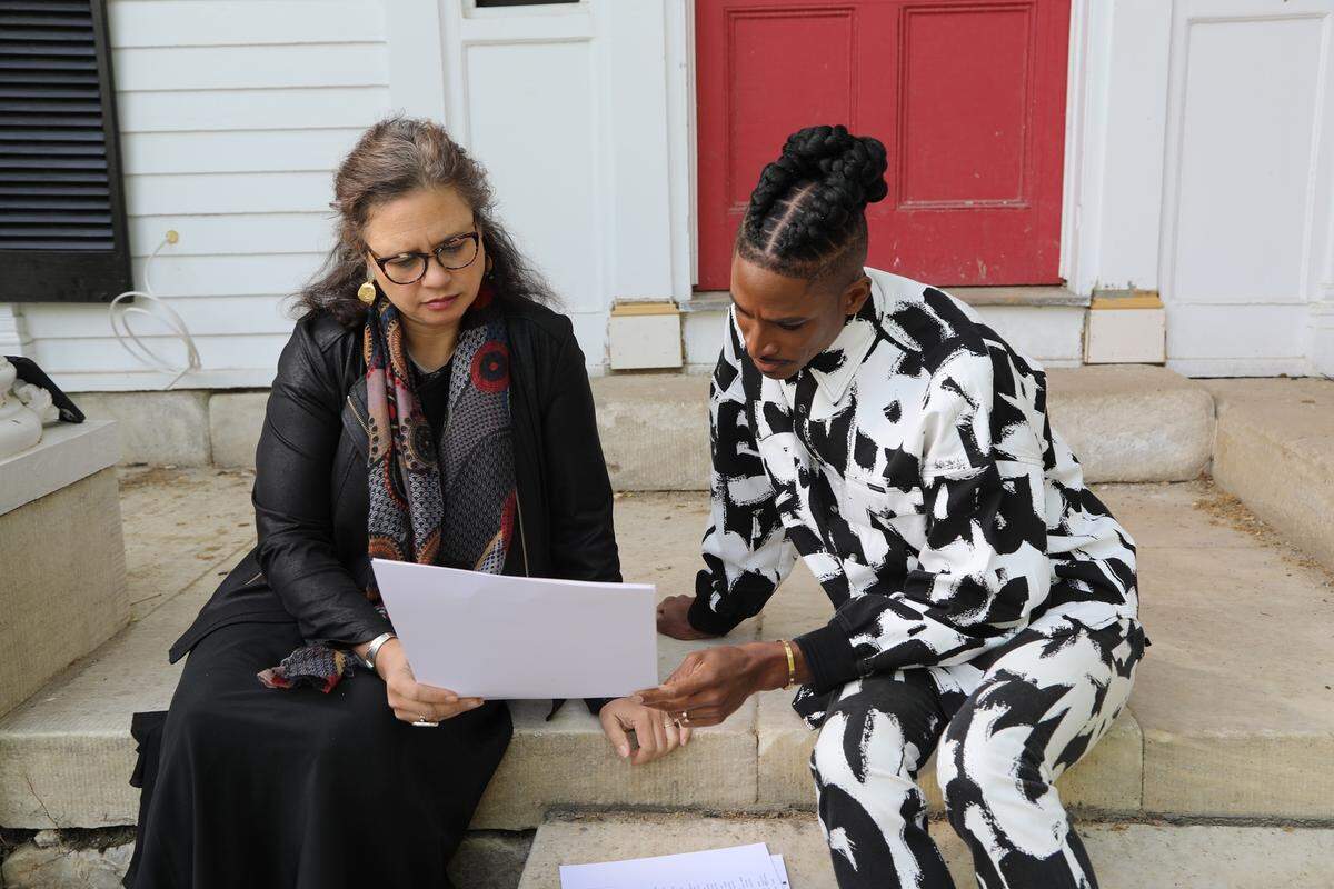 Historian Dr. Kendra T. Field and Robert Hartwell looking at historical documents and discussing the house’s history.