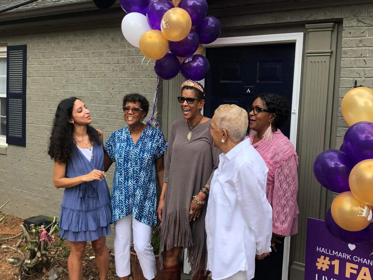 Taborah Adams of Cary, center, with her sisters, mother and niece, face the Hallmark Channel’s cameras Thursday after Adams was named winner of the network’s No. 1 fan contest.