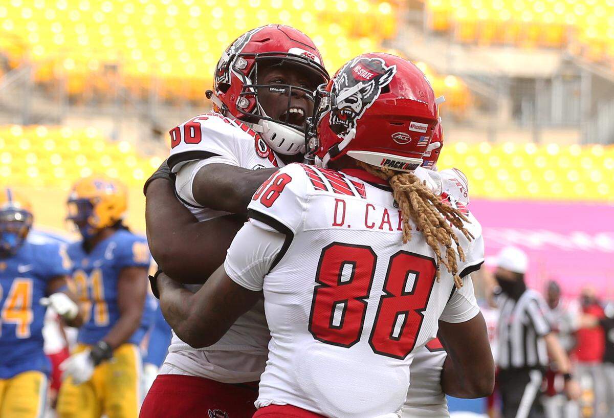 N.C. State’s Emeka Emezie (86) celebrates his game winning touchdown with wide receiver Devin Carter (88) during the Wolfpack’s victory over the Pittsburgh Panthers at Heinz Field Saturday, Oct. 3, 2020.
