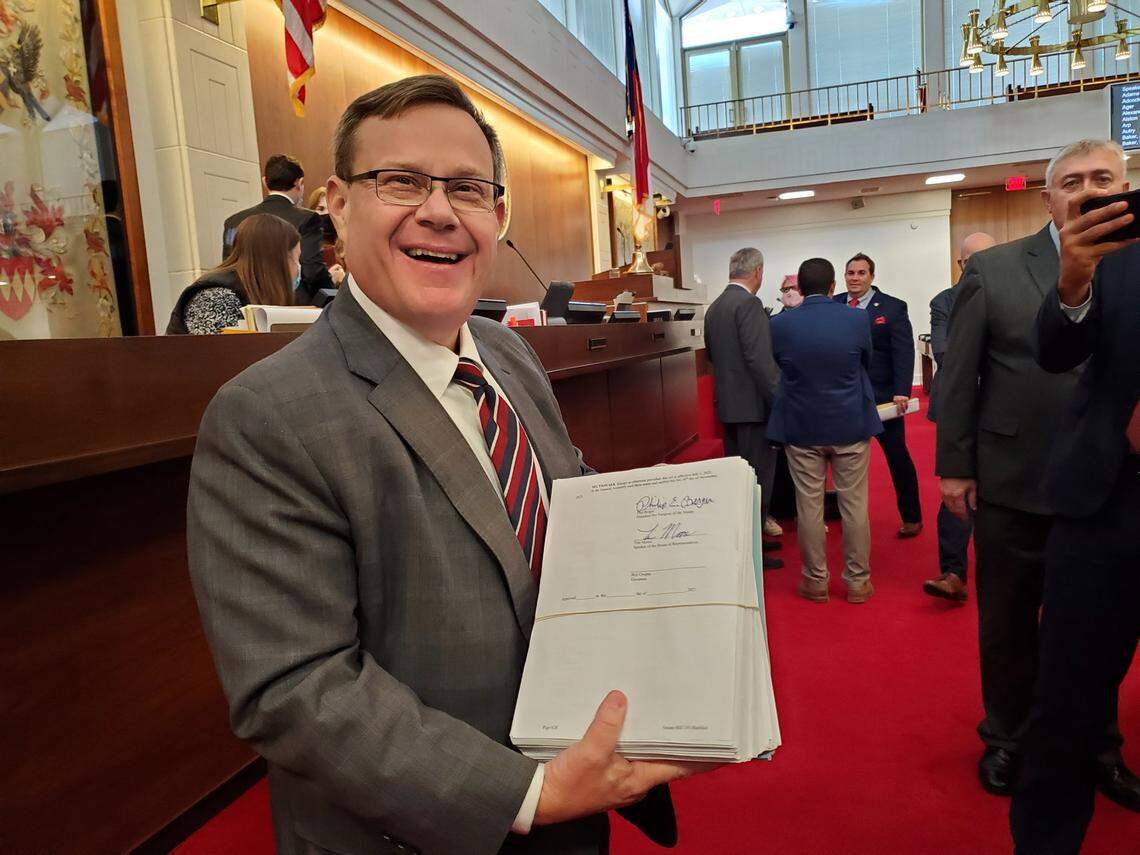North Carolina House Speaker Tim Moore shows reporters the state budget he had just signed on the House floor on Thursday, Nov. 18, 2021.