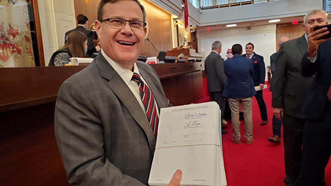 North Carolina House Speaker Tim Moore shows reporters the state budget he had just signed on the House floor on Thursday, Nov. 18, 2021.