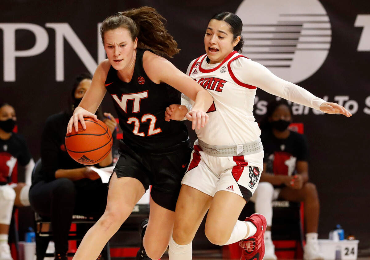 Virginia Tech’s Cayla King (22) drives by N.C. State’s Raina Perez (2) during the first half of N.C. State’s game against Virginia Tech at Reynolds Coliseum in Raleigh, N.C., Sunday, January 24, 2021.
