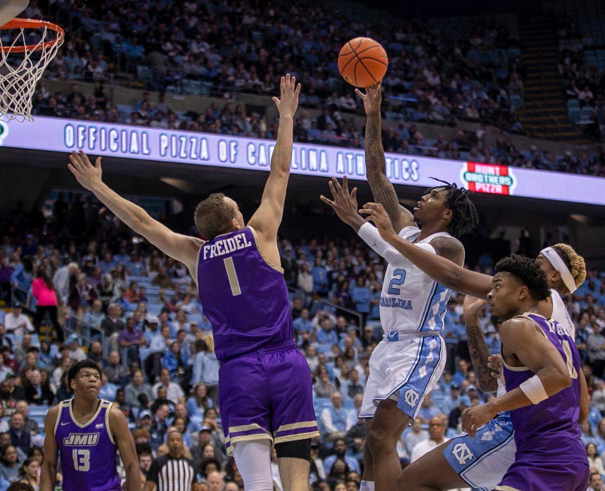 North Carolina’s Caleb Love (2) drives to the basket against James Madison’s Noah Freidel (1) in the first half on Sunday, November 20, 2022 at the Smith Center in Chapel Hill, N.C.