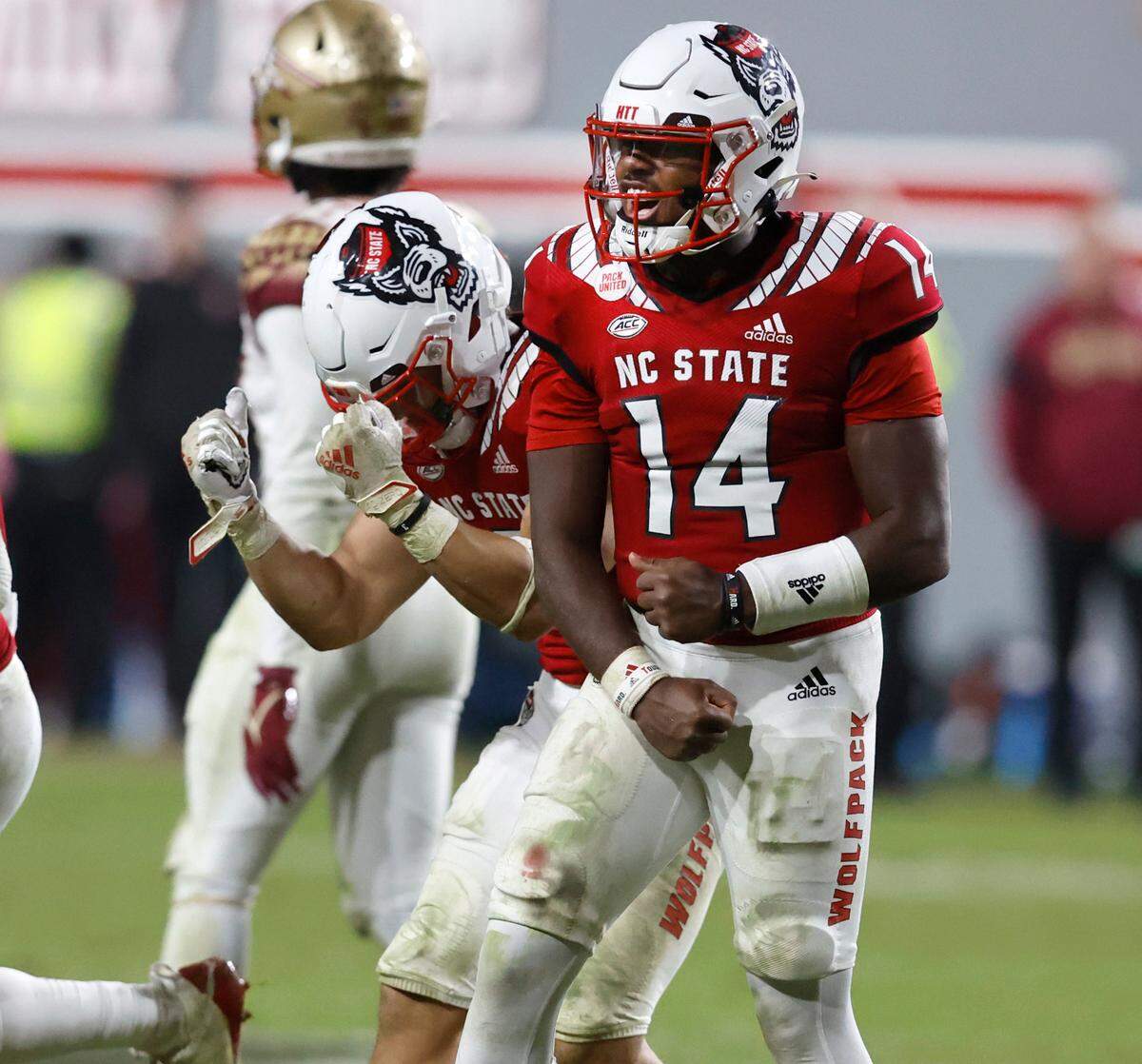 N.C. State quarterback Jack Chambers (14) and Jordan Houston (3) celebrate as time runs out during N.C. State’s 19-17 victory over Florida State at Carter-Finley Stadium in Raleigh, N.C., Saturday, Oct. 8, 2022.