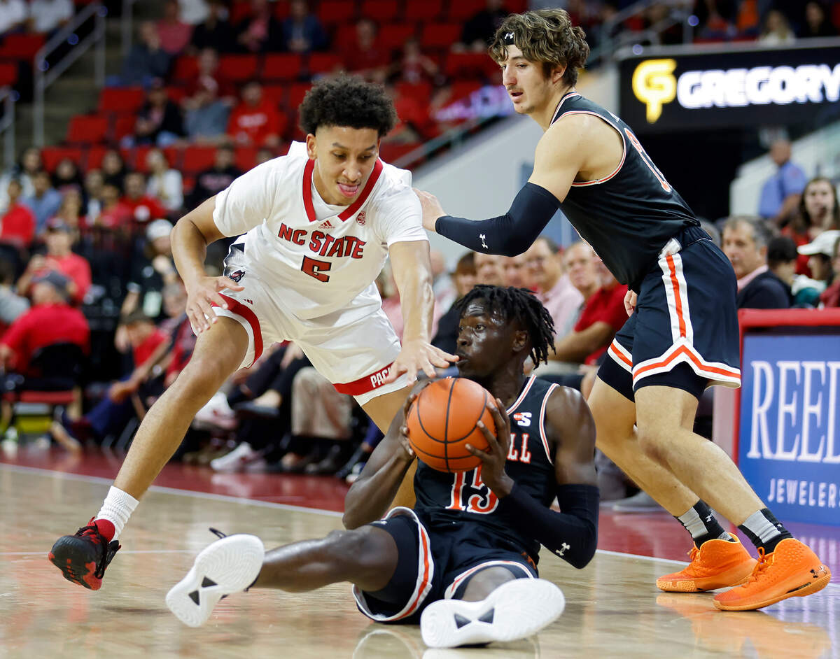 Campbell Fighting Camels forward Jay Pal looks to pass around North Carolina State Wolfpack guard Jack Clark during the first half of a men’s basketball game at PNC Arena in Raleigh, N.C. on Friday, Nov. 11, 2022.