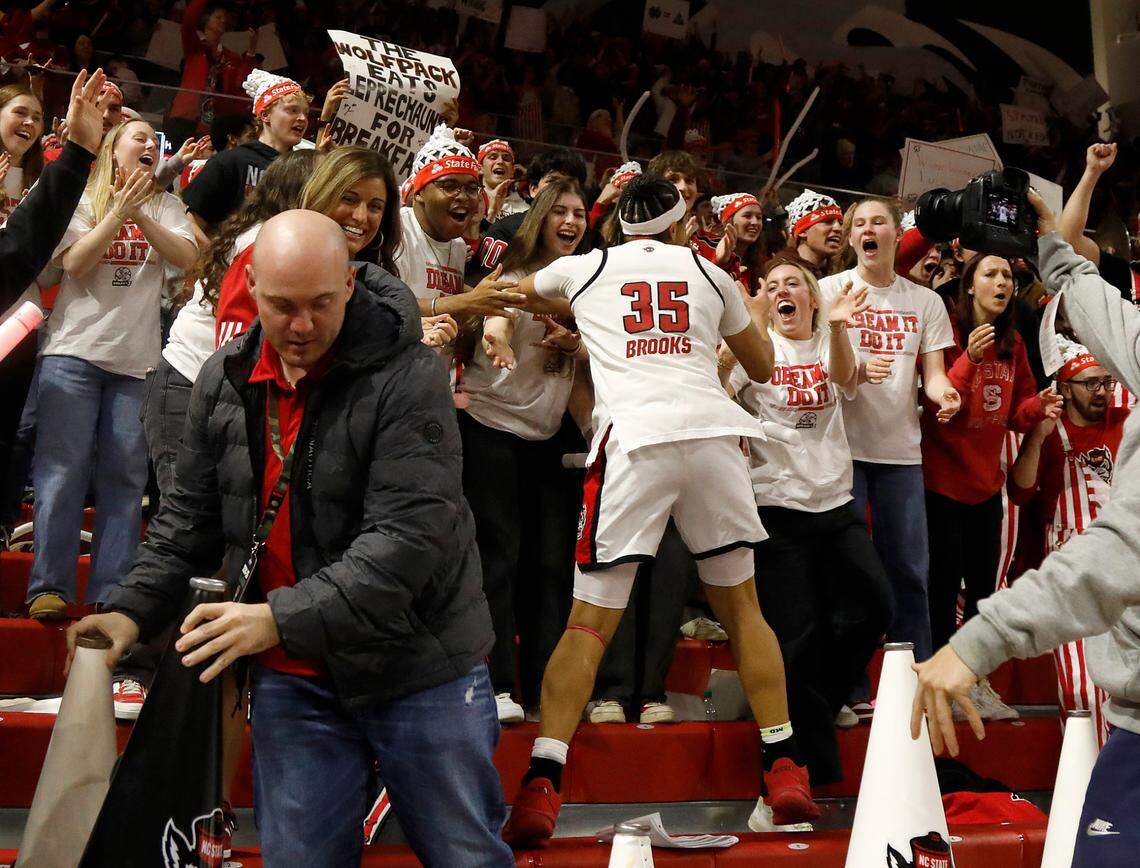 N.C. State’s Zoe Brooks celebrates with the student section following the Wolfpack’s 104-95 double overtime win over Notre Dame on Sunday, Feb. 23, 2025, at Reynolds Coliseum in Raleigh, N.C.