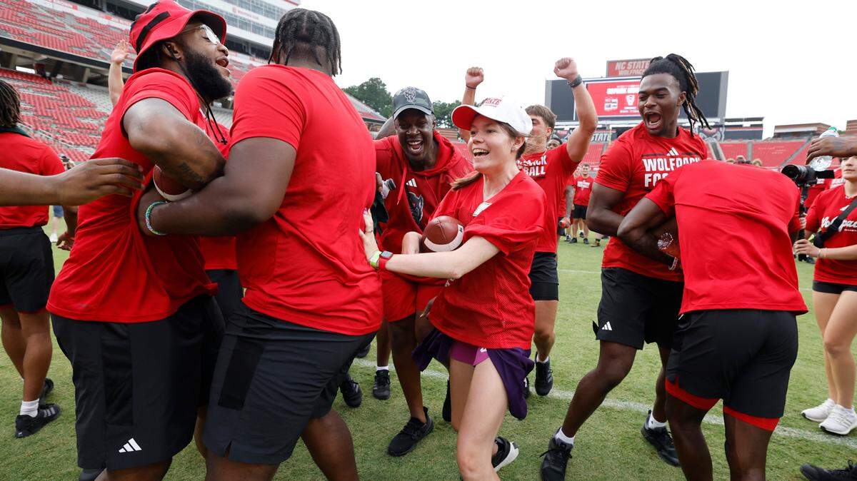 With players blocking for her Kimberly Kelly heads to the end zone to score during N.C. State football’s Victory Day at Carter-Finley Stadium in Raleigh, N.C., Friday, August 2, 2024. Victory Day is a partnership between the Wolfpack and GiGi’s Playhouse, a Down Syndrome achievement center in Raleigh. The event provided 52 cognitively and physically impaired people the chance to be football stars for the night. They tried on uniforms, met the players and coaches, ran through the tunnel and competed in drills with the players.