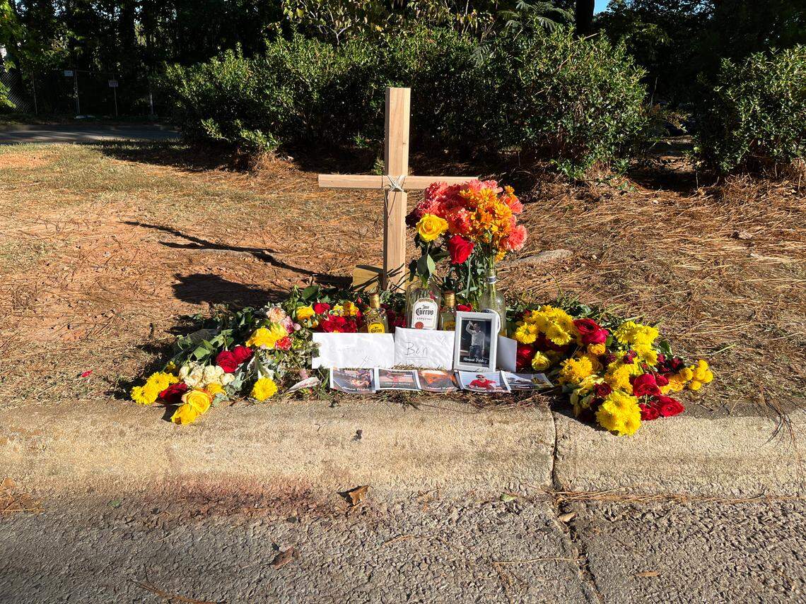 Flowers and photos left at a memorial seen Wednesday, Oct. 20, 2021 near the site where N.C. State University student Benjamin DeRose was hit by a car on Crest Road, in Raleigh, North Carolina.