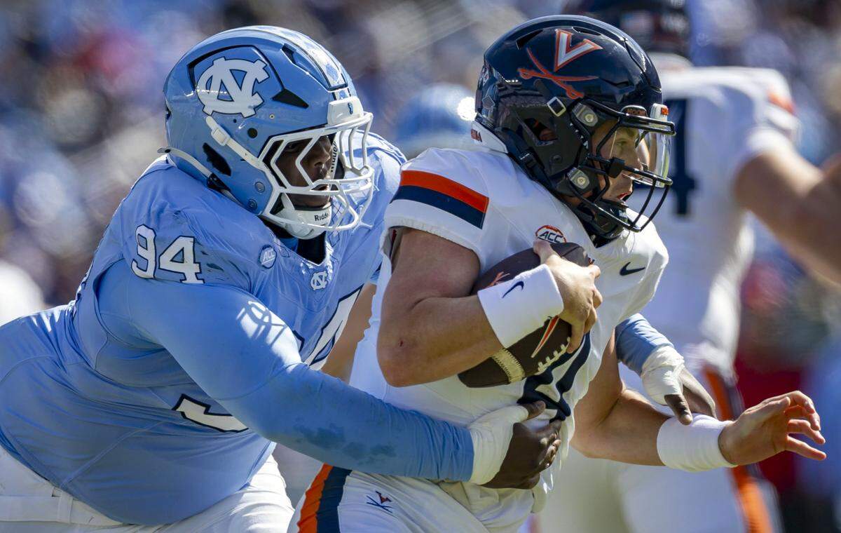 North Carolina defensive lineman Isiah Johnson (94) sacks Virginia quarterback Chandler Morris (4) for a 15 yard loss in the second quarter on Saturday, October 25, 2025 at Kenan Stadium in Chapel Hill, N.C. 
