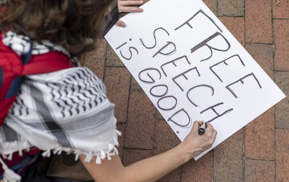 A demonstrator creates a poster on free speech, prior to rally for UNC associate professor Dwayne Dixon, who has been placed on administrative leave on Wednesday, October 1, 2025 in Chapel Hill, N.C. 