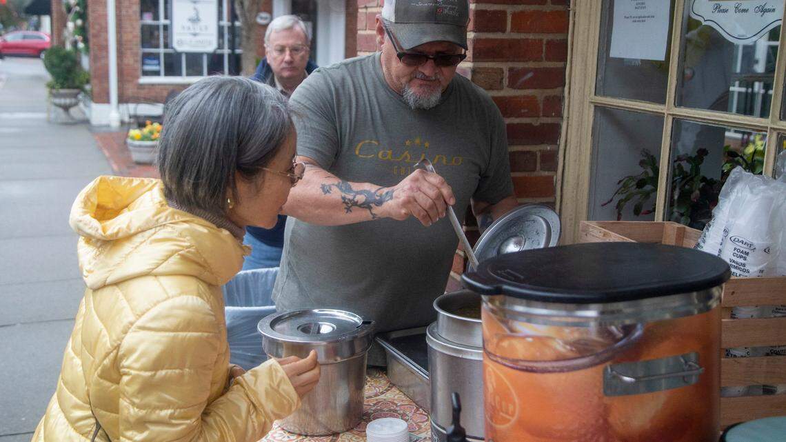 Robert Chanonat serves free hot soup to Okyoun Janicki on Wednesday Dec. 7, 2022 outside Sweet Basil Cafe in Southern Pines shortly after power was restored.