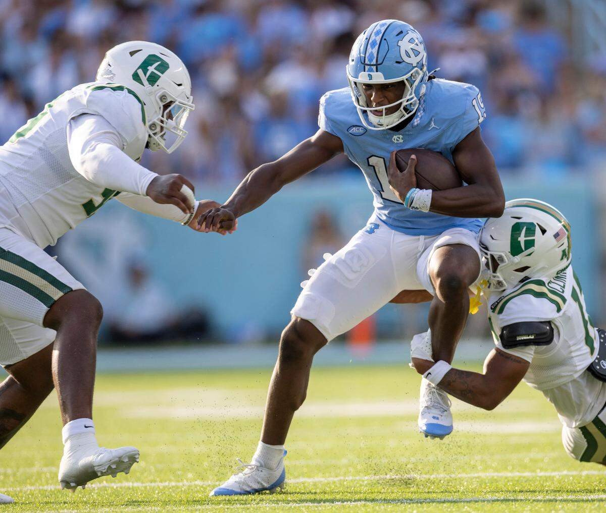 Charlotte defensive lineman Dre Martin (99) and defensive back CJ Clinkscales (12) work to slow North Carolina quarterback Conner Harrell (15) in the third quarter on Saturday, September 7, 2024 at Kenan Stadium in Chapel Hill, N.C.