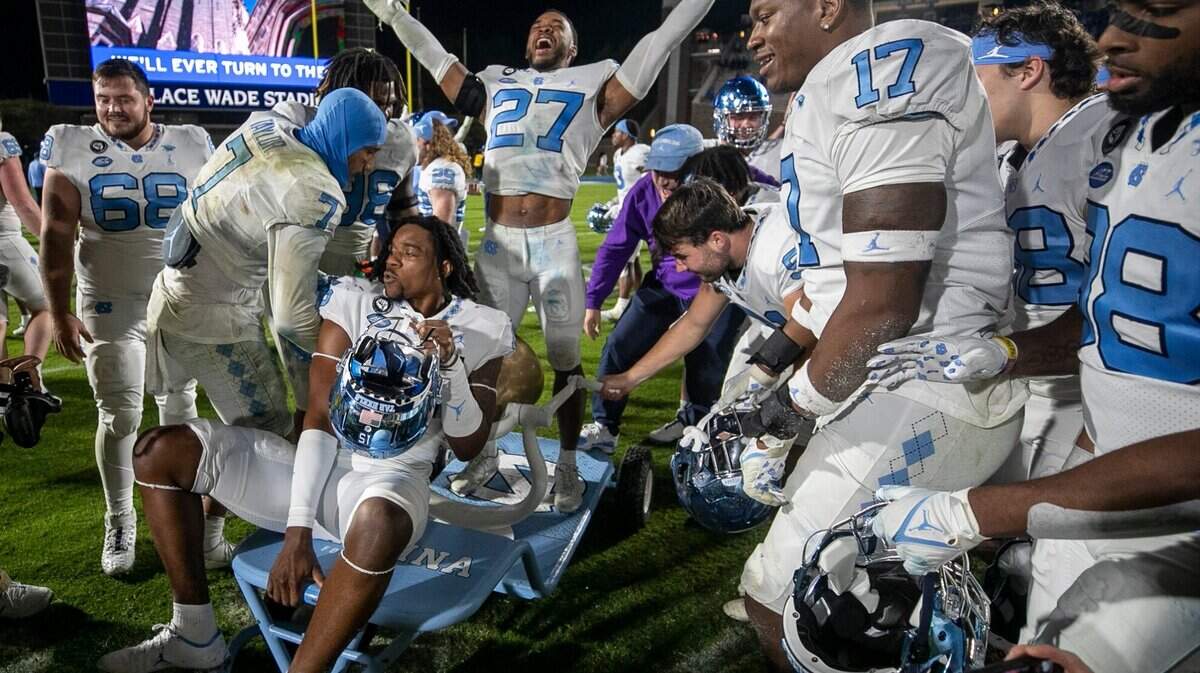 North Carolina’s Giovanni Biggers (27) celebrates with the victory bell and his teammates after their 38-35 victory over Duke on Saturday, October 15, 2022 at Wallace-Wade Stadium in Durham, N.C.