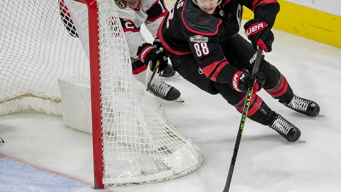 Ottawa’s Austin Watson (16) works to stop Carolina’s Hurricanes’ Martin Necas (88) as he moves the puck behind the Ottawa goal in overtime on Tuesday, April 4, 2023 at PNC Arena in Raleigh, N.C.