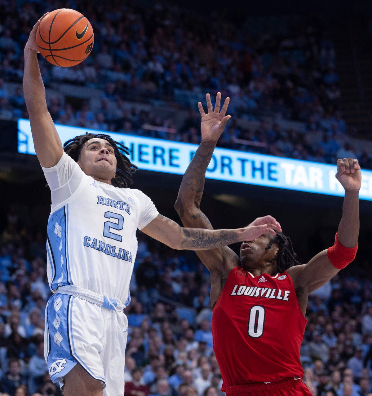 North Carolina’s Elliot Cadeau (2) breaks two the basket for a dunk on a fast break in the first half against Louisville’s Mike James (0) on Wednesday, January 17, 2024 at the Smith Center in Chapel Hill, N.C.