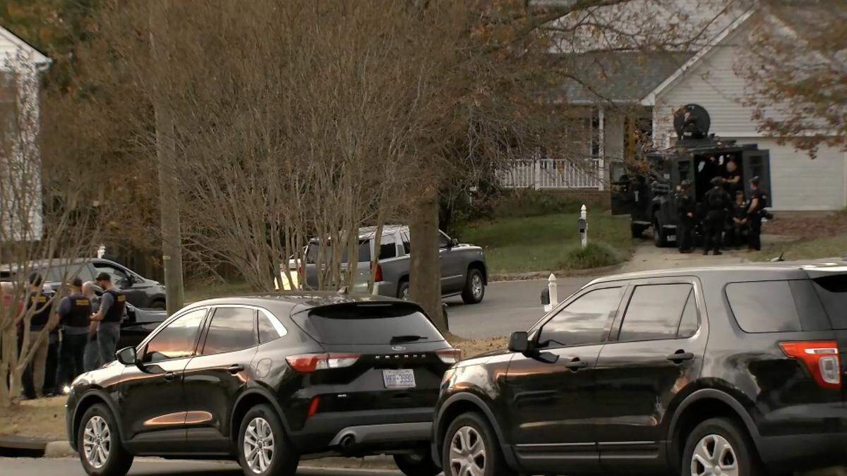 Raleigh police officers in a tactical vehicle outside of a residence on Newby Court in Raleigh where two men were taken into custody in connection with shots fired into vehicles.