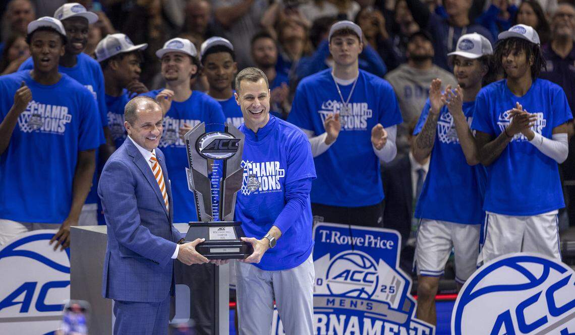 Duke coach John Scheyer accepts the ACC Tournament Championship trophy from Commissioner Jim Phillips following the Blue Devils’ 73-62 victory over Louisville in the ACC Tournament Championship game on Saturday, March 15, 2025 at Spectrum Center in Charlotte, N.C.