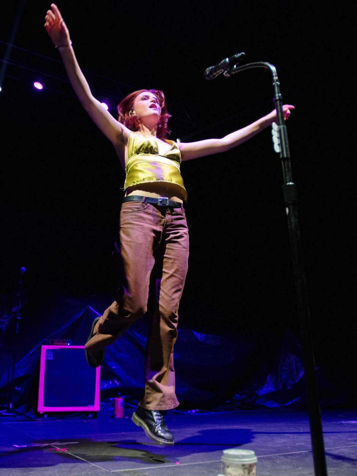 Katie Gavin, lead singer for MUNA, leaps into the air during their set opening for Phoebe Bridgers in concert at Raleigh, N.C.’s Red Hat Amphitheater Tuesday night, Sept. 21, 2021.
