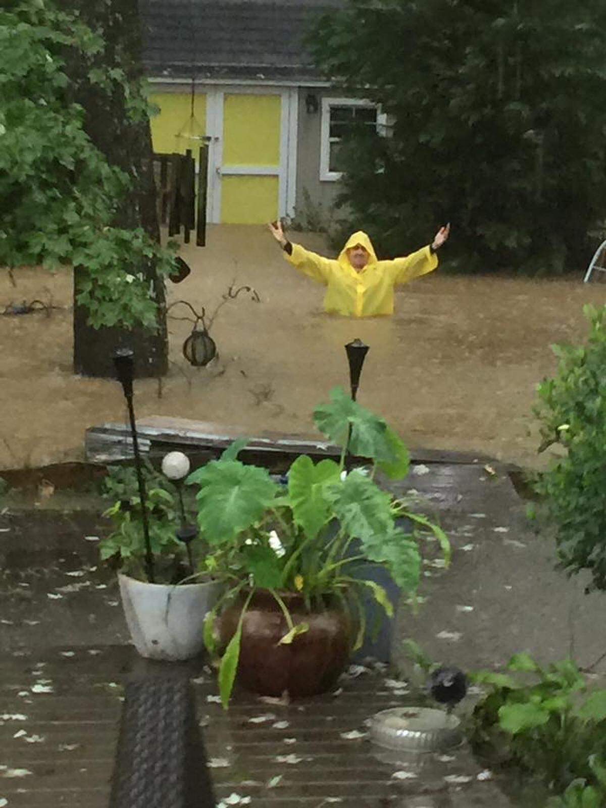 Edgar Vardanian, who is 6-foot-three, stands in his backyard during a storm in Raleigh.