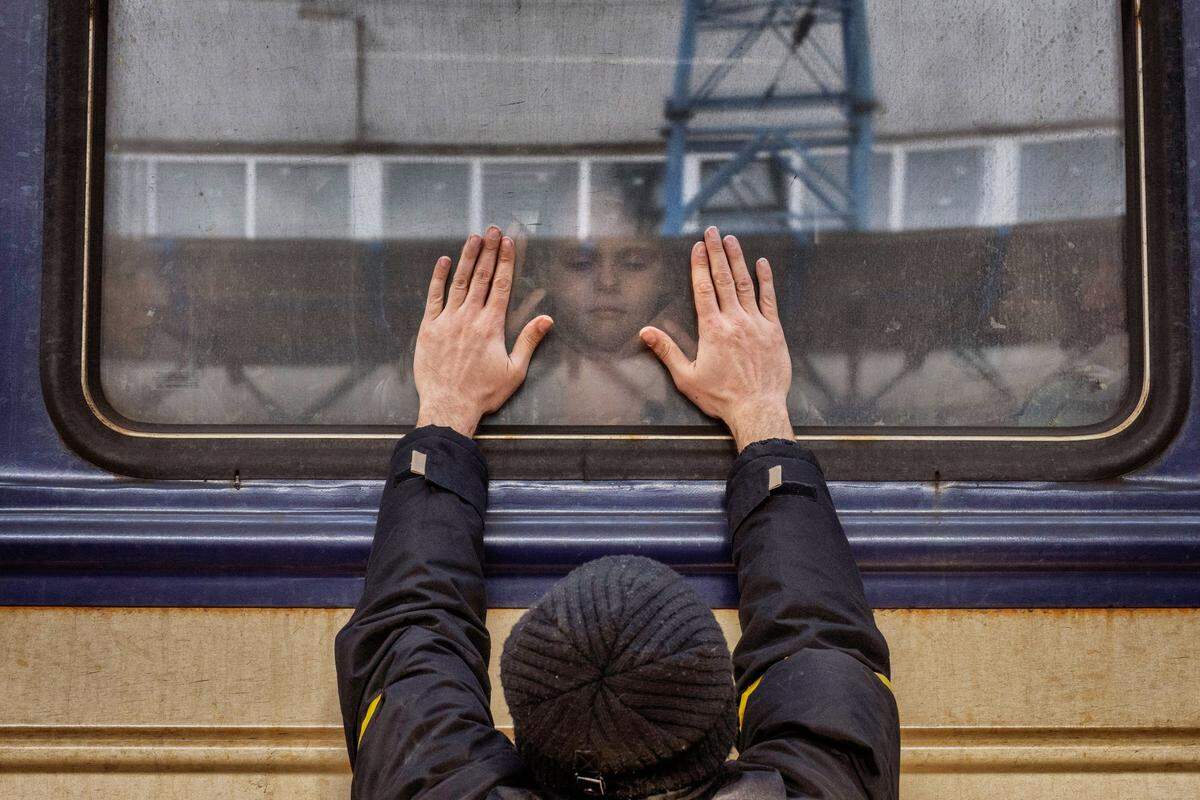 Aleksander, 41, presses his palms against the window as he says goodbye to his daughter Anna, 5, on a train to Lviv at the Kyiv station, Ukraine, Friday, March 4. 2022. Aleksander has to stay behind to fight in the war while his family leaves the country to seek refuge in a neighbouring country. (AP Photo/Emilio Morenatti)