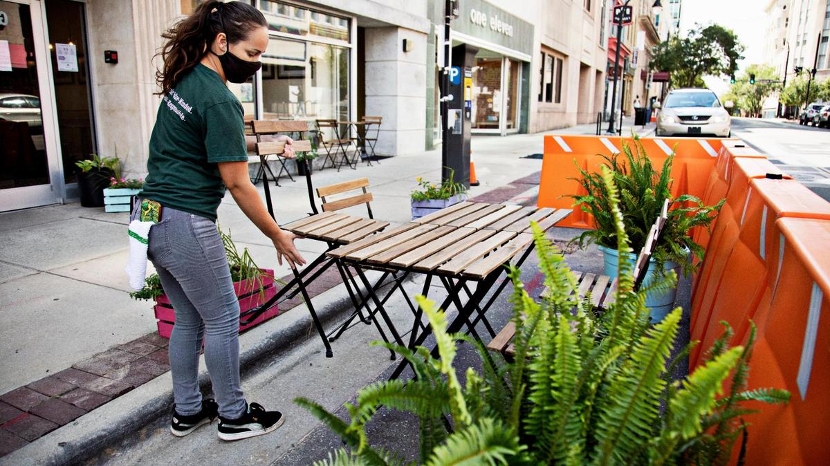 Vivian Voss, a server and farmhand for COPA Restaurant in downtown Durham, sets up their outdoor tables along the sidewalk and in the parklet that allows for more outdoor dining space on Friday afternoon, July 31, 2020.