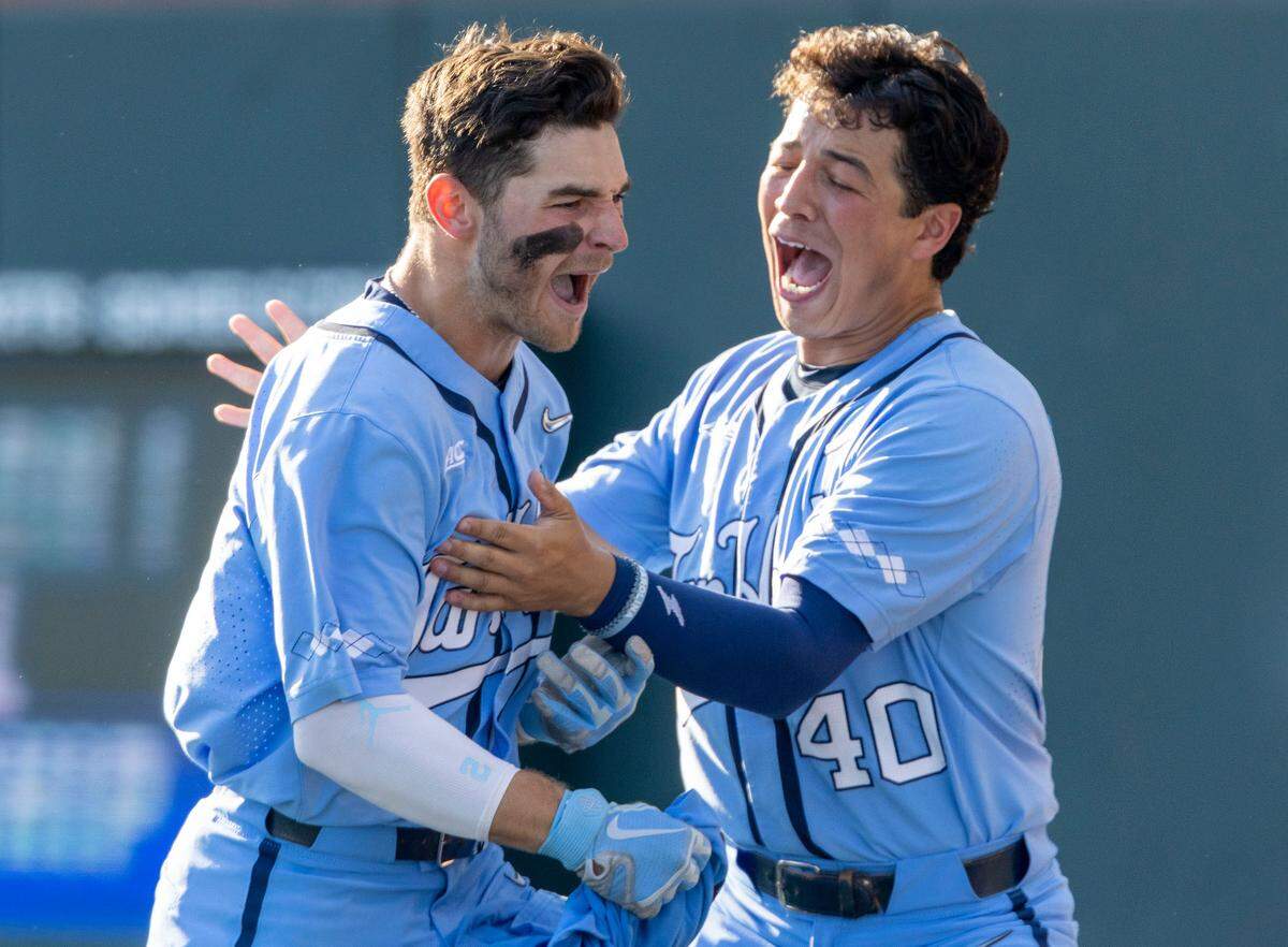 North Carolina’s Angel Karate (40) celebrates with teammate Mikey Madej (2) after a 3 RBI home run by Madej in the first inning to give the Tar Heels’ a 4-0 lead over VCU in the first inning against VCU on Monday, June 6, 2022 during during the NCAA Regional championship at Boshamer Stadium in Chapel Hill, N.C.