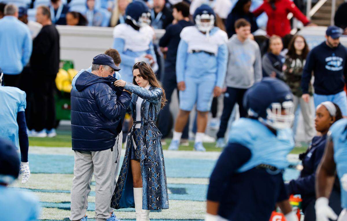Jordon Hudson, girlfriend of UNC football coach Bill Belichick, adjusts his coat during UNC football’s Practice Like a Pro open practice at Kenan Stadium in Chapel Hill, N.C., Saturday, April 12, 2025.