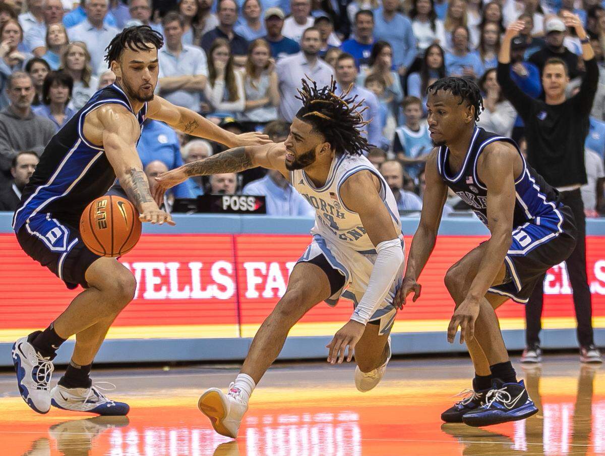 Duke’s Dereck Lively II (1) and Jeremy Roach (3) force a turnover by North Carolina’s R.J. Davis (4) in the second half on Saturday, March 4, 2023 at the Smith Center in Chapel Hill, N.C.