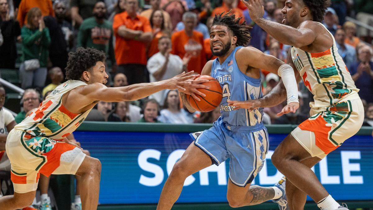 North Carolina’s R.J. Davis (4) drives to the basket between Miami’s Nijel Pack (24) and Norchad Omier (15) in the second half on Saturday, February 10, 2024 at the Watsco Center in Coral Gables, Florid