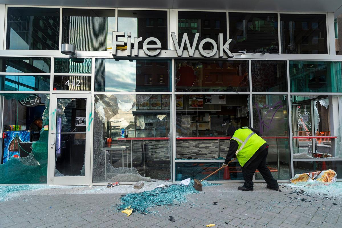 Broken glass is swept by workers on Fayetteville St. after protestors vandalized many downtown businesses Saturday night in response to the death of George Floyd in the custody of Minneapolis Police on Monday, joining protestors in major cities across the country, on Sunday, May 31, 2020, in Raleigh, N.C.