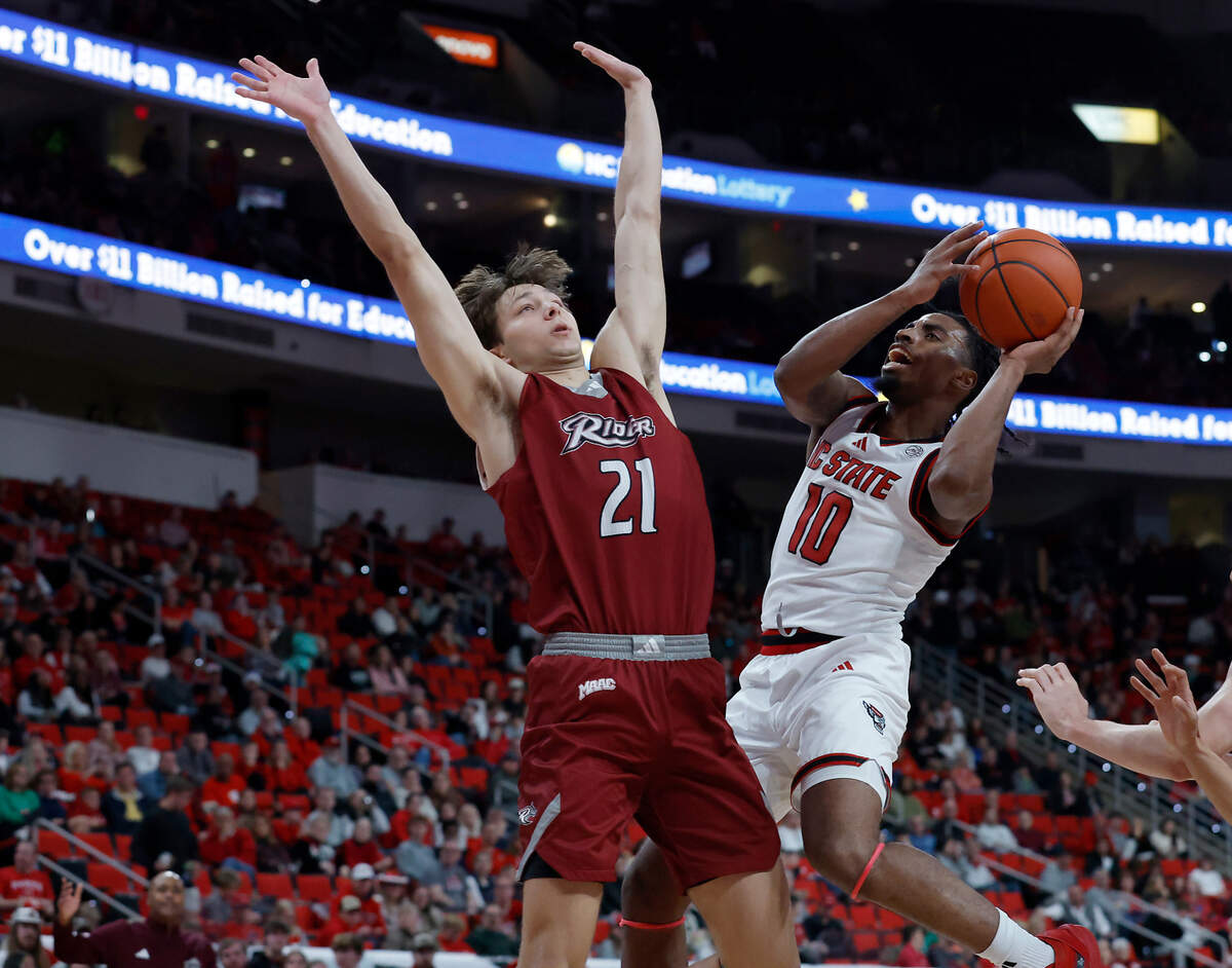 N.C. State’s Marcus Hill drives to the basket against Rider’s Cole McCabe during the first half of the Wolfpack’s game on Sunday, Dec. 22, 2024, at Lenovo Center in Raleigh, N.C.