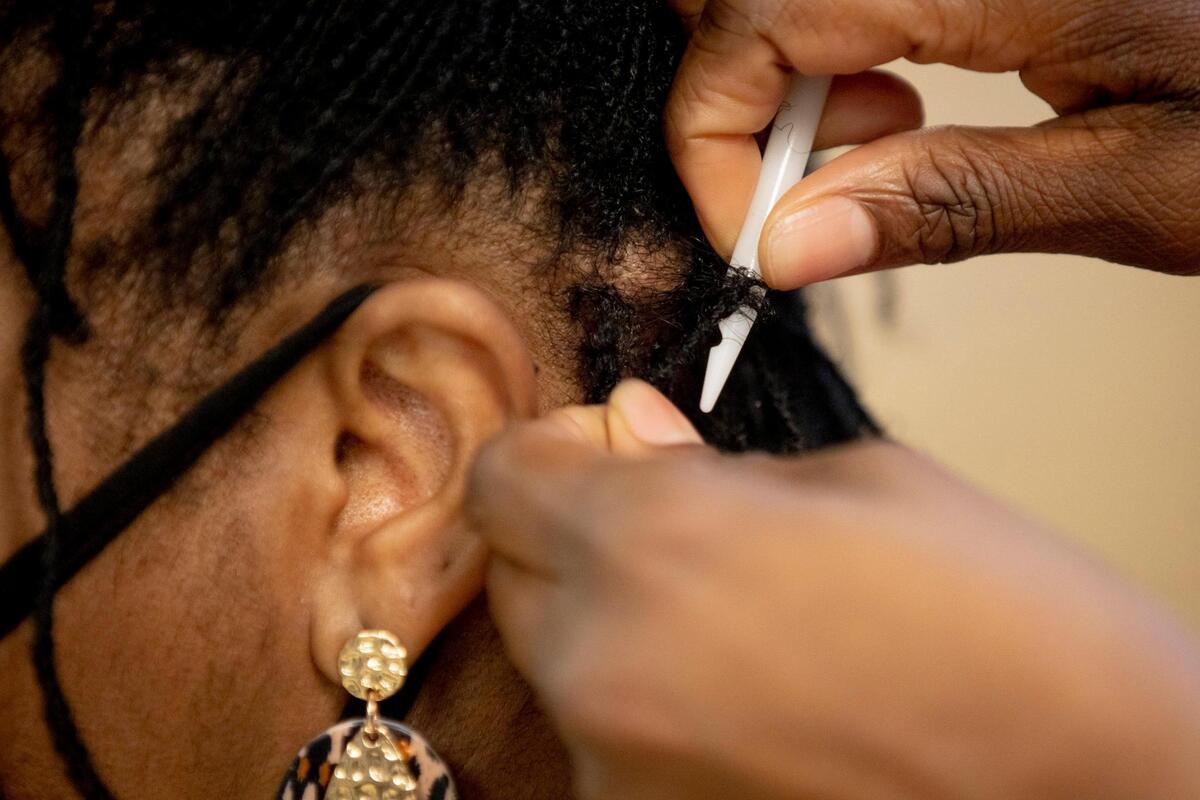 Denise Browning, left, has her Sisterlocks retightened in The Barbee Shop by Wendi Barbee, right, on Friday, Jan. 15, 2021, in Durham, N.C.