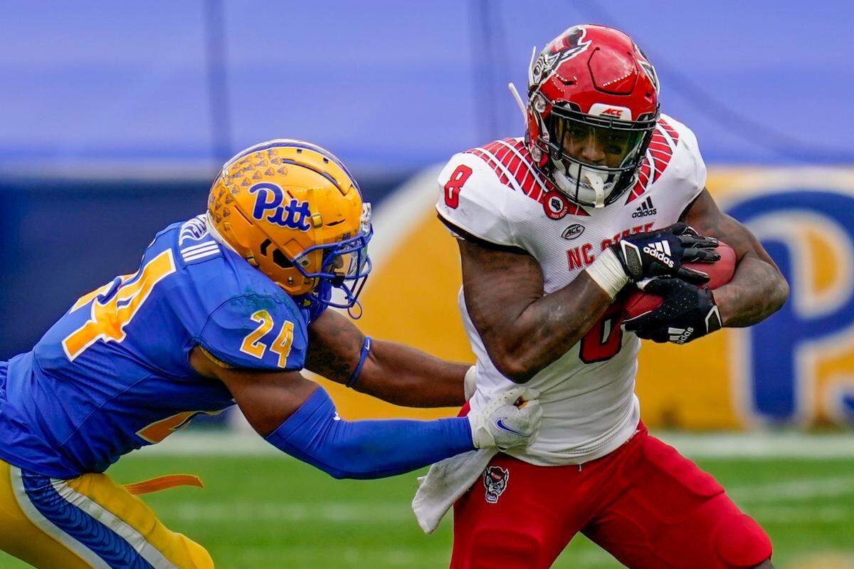 North Carolina State running back Ricky Person Jr. (8) runs away from Pittsburgh Panthers linebacker Phil Campbell III (24) for a first down during the second half of an NCAA college football game, Saturday, Oct. 3, 2020, in Pittsburgh. North Carolina State won 30-29.