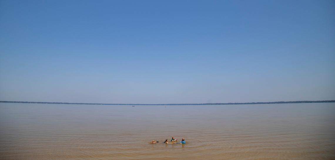 Children from the Brunswick County Wild + Free homeschool group play in the shallow water at Lake Waccamaw State Park.