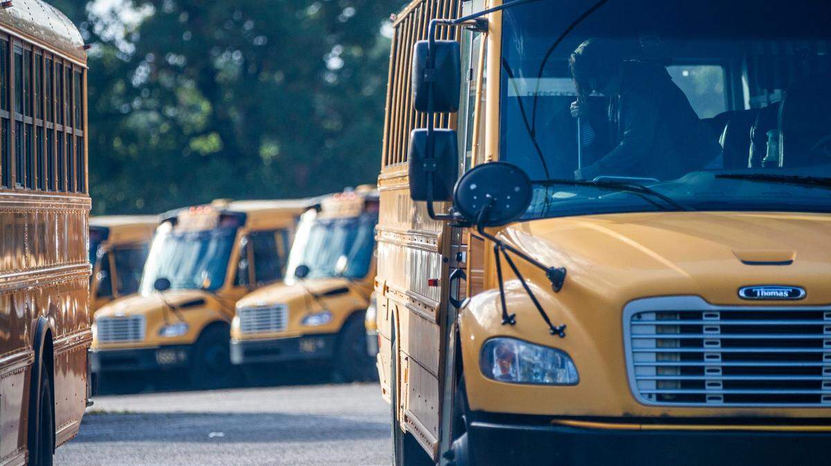 A Wake County school bus driver sweeps their bus in a parking area on Capital Boulevard in Raleigh after completing a morning route Oct. 29, 2021.
