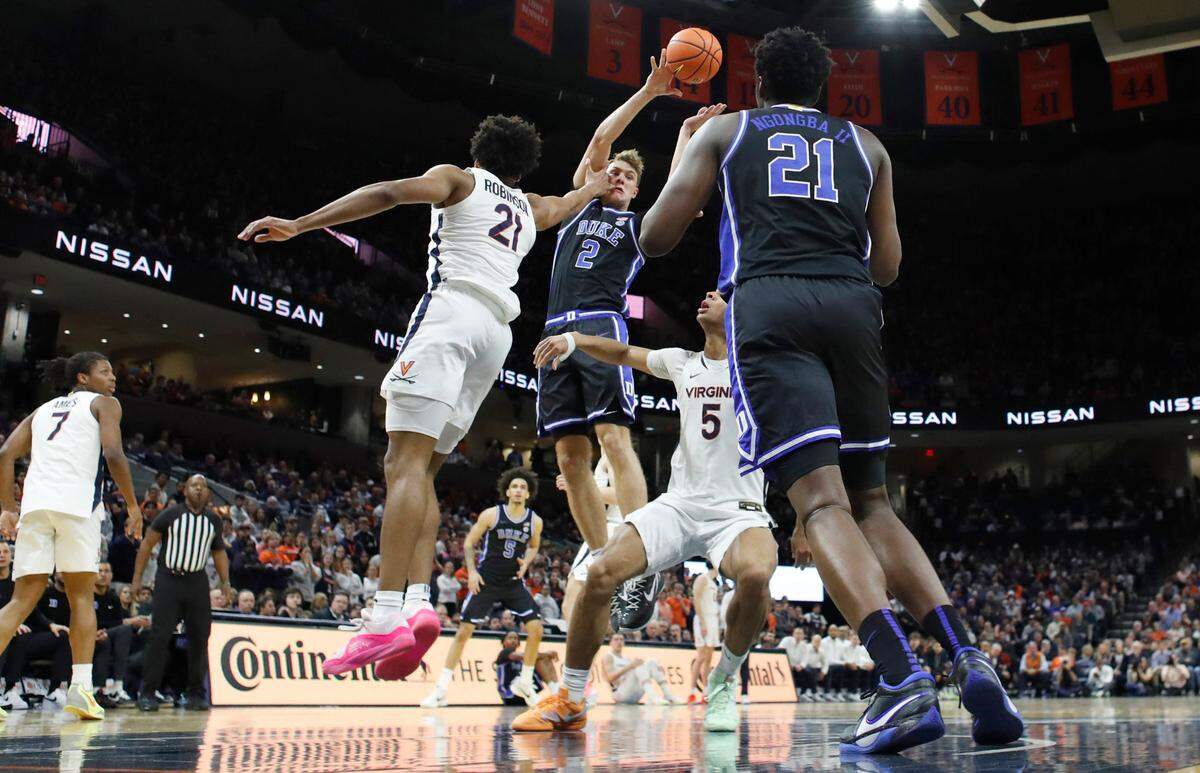 Duke’s Cooper Flagg (2) passes over the defense of Virginia’s Anthony Robinson (21) to Patrick Ngongba II (21) during Duke’s 80-62 victory over Virginia at John Paul Jones Arena in Charlottesville, Va., Monday, Feb. 17, 2025.