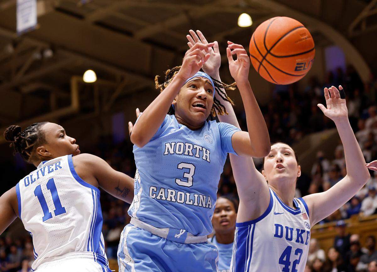 Duke’s Jordyn Oliver and Mia Heide battle North Carolina’s Kennedy Todd-Williams for a loose ball during the second half of the Tar Heels’ 45-41 win over Duke on Sunday, Feb. 26, 2023, at Cameron Indoor Stadium in Durham, N.C.