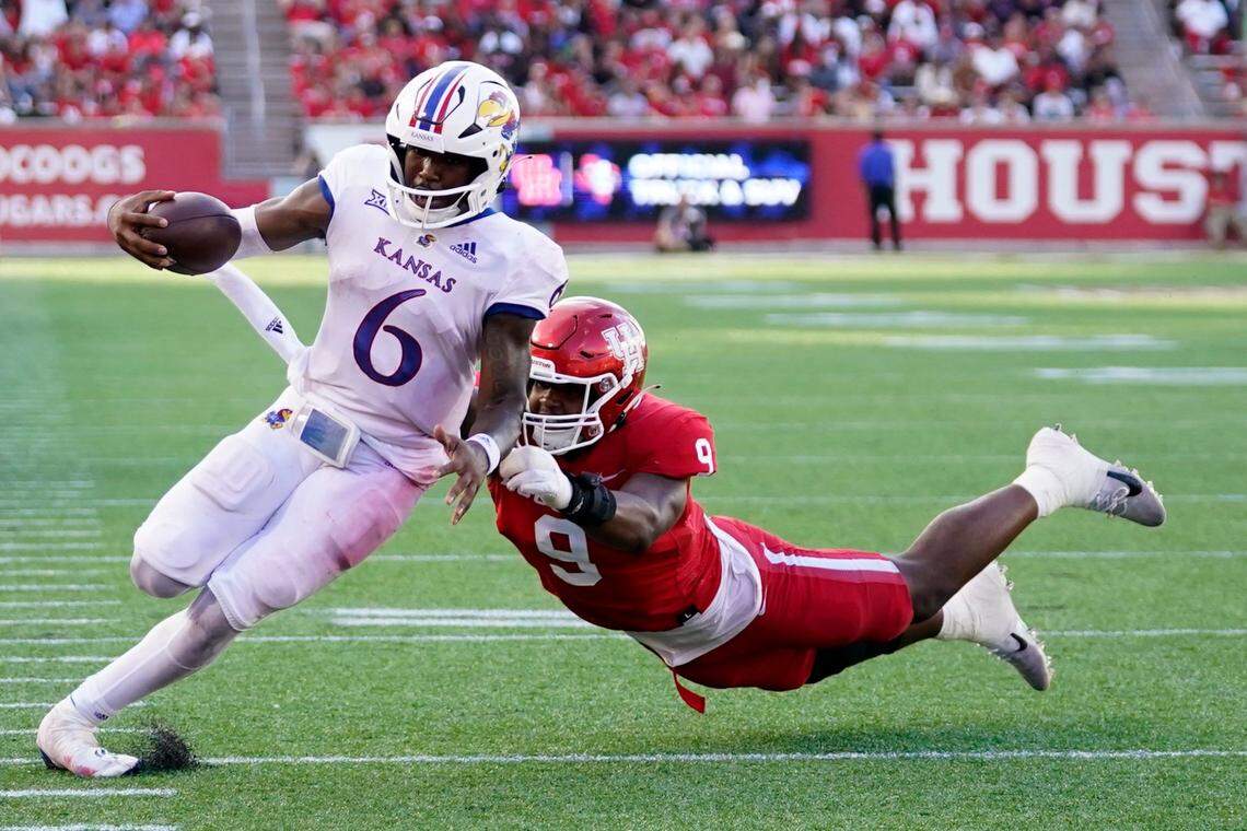 Kansas quarterback Jalon Daniels (6) escapes a tackle by Houston defensive lineman Nelson Ceaser en route to a touchdown during the second half of an NCAA college football game, Saturday, Sept. 17, 2022, in Houston. (AP Photo/Eric Christian Smith)
