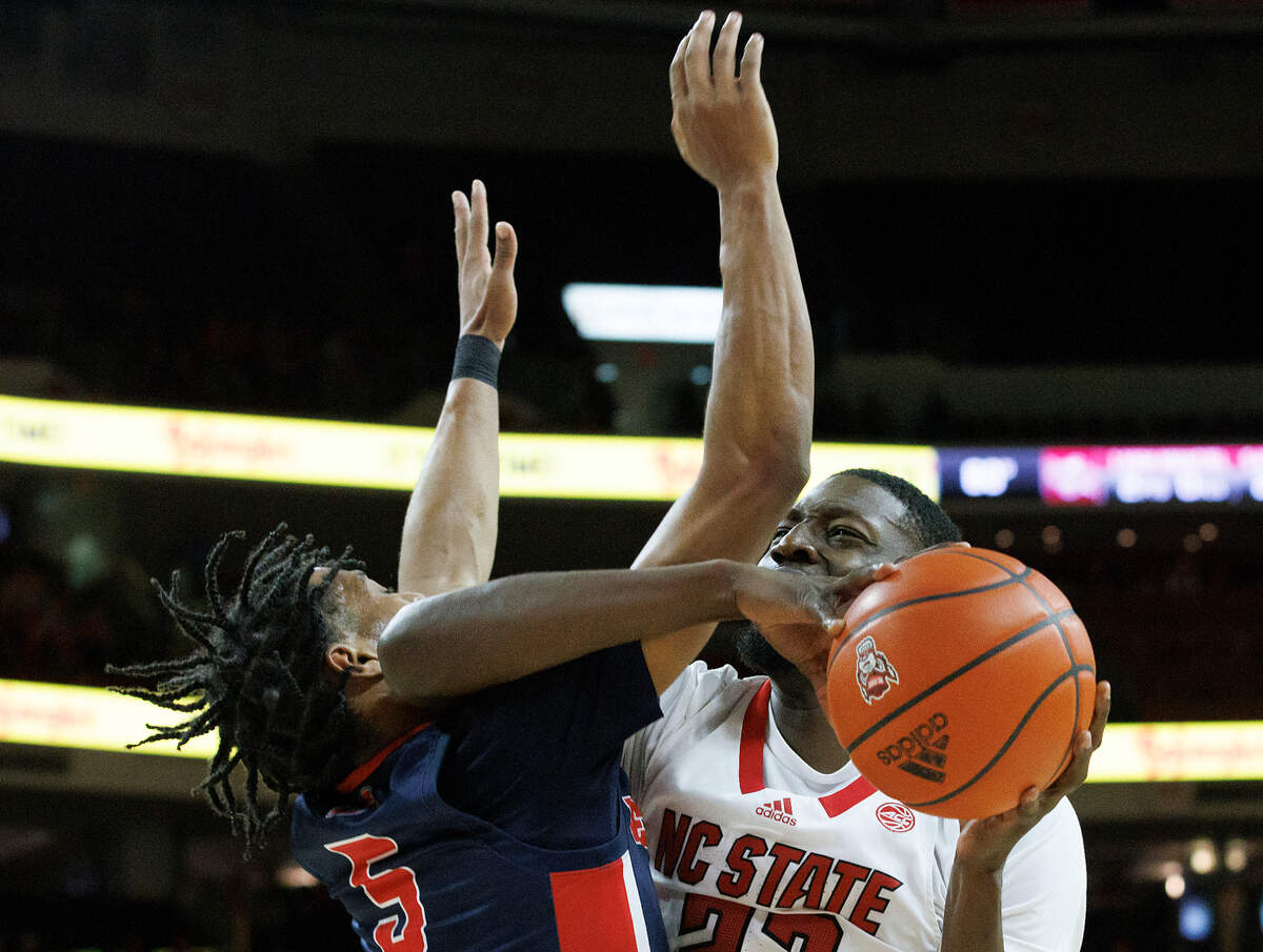 N.C. State’s Mohamed Diarra drives against Detroit’s Kyle LeGreair during the first half of the Wolfpack’s 83-66 win on Saturday, Dec. 23, 2023, at PNC Arena in Raleigh, N.C.