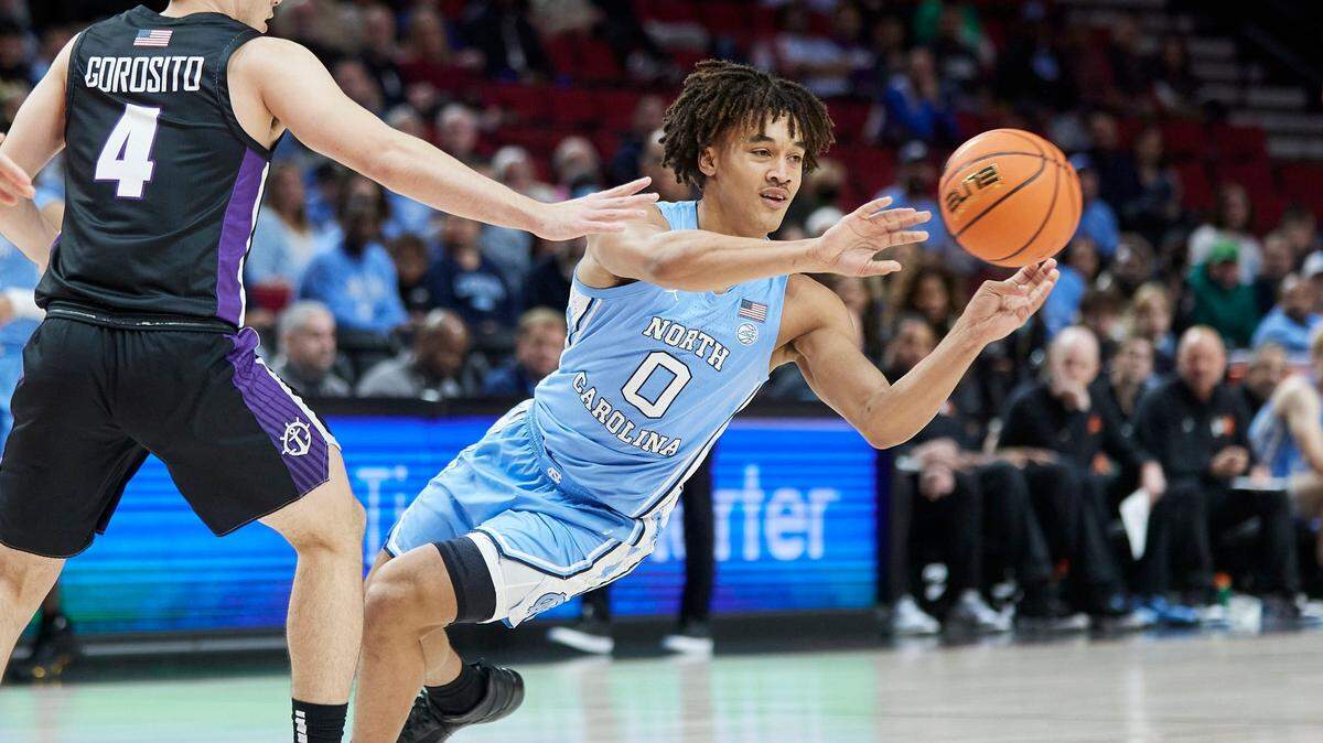 North Carolina guard Seth Trimble, right, passes the ball away from Portland guard Juan Sebastian Gorosito during the first half of an NCAA college basketball game in the Phil Knight Invitational tournament Portland, Ore., Thursday, Nov. 24, 2022. (AP Photo/Craig Mitchelldyer)