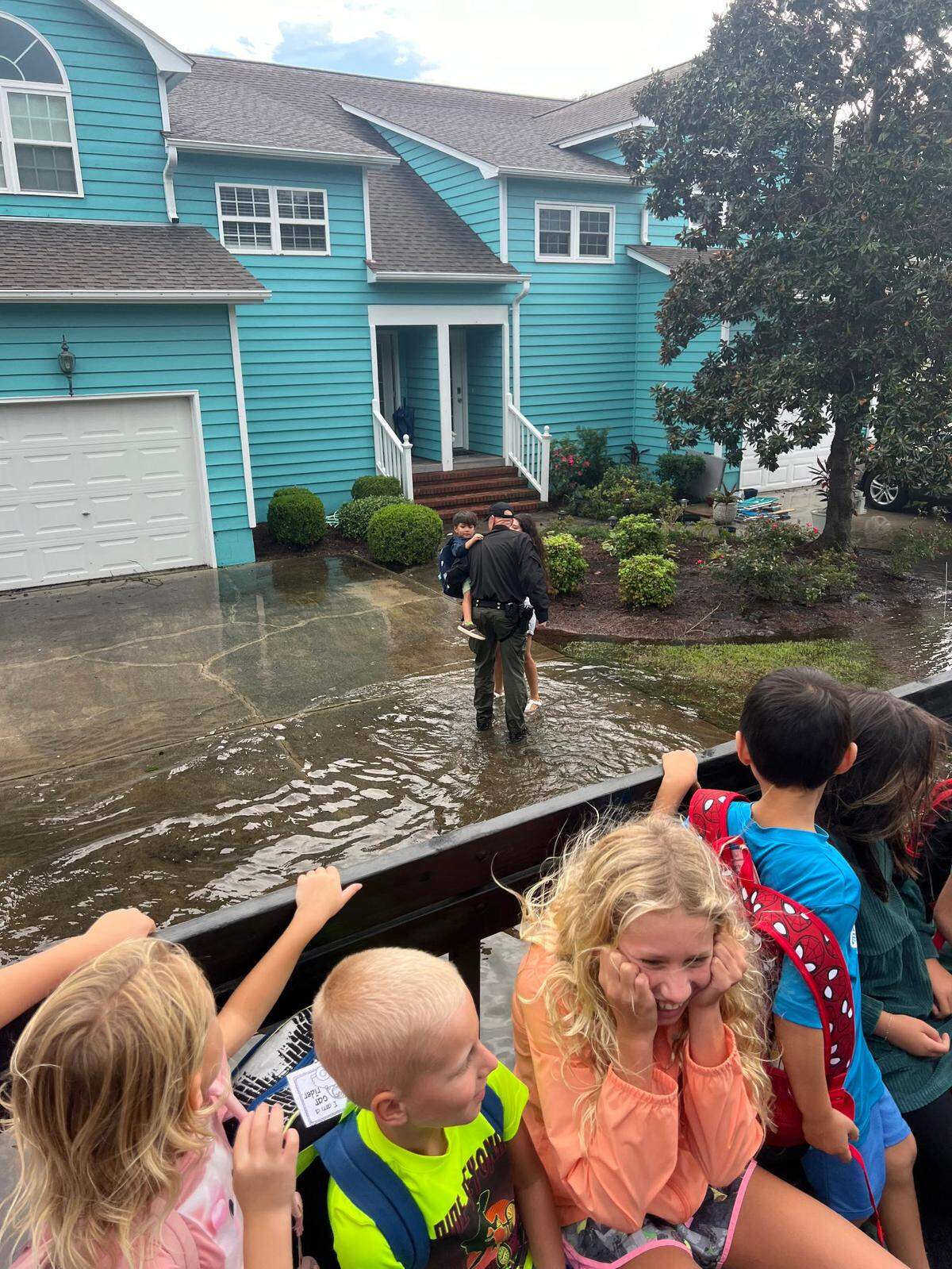 New Hanover Sheriff’s Dept. officers assist school students in getting home in floodwaters Monday, Sept. 17, 2024. A high-water vehicle was used to move students and officers through flooded streets.