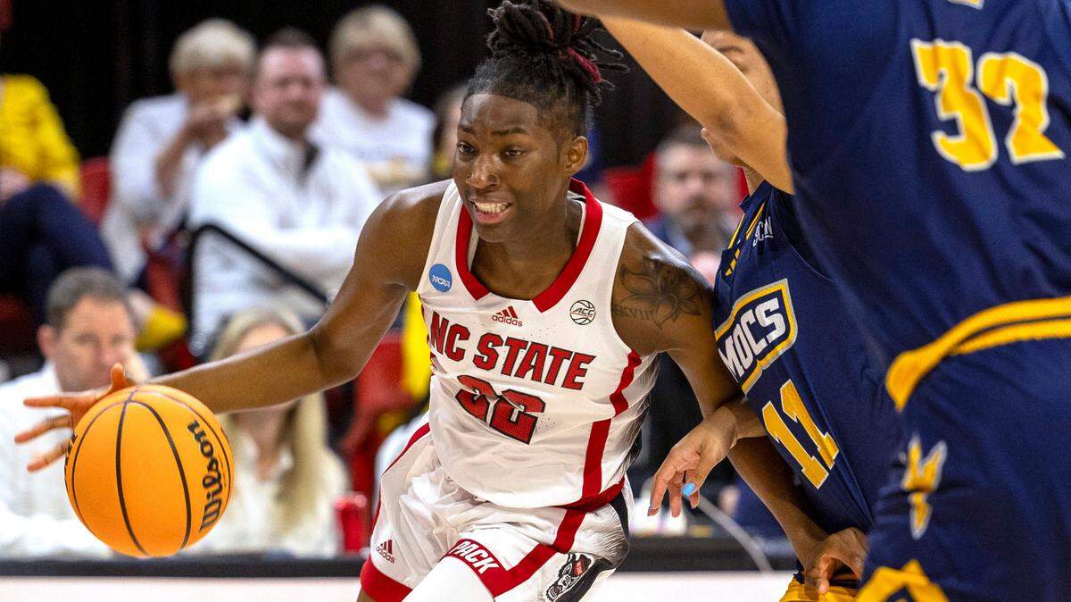 NC State’s Saniya Rivers (22) drives past Chattanooga’s Caia Elisaldez (11) and Raven Thompson (32) during the first half of their game in the first round of the NCAA Division I Women’s Basketball Championship at Reynolds Coliseum in Raleigh, NC on Saturday, March 23, 2024.