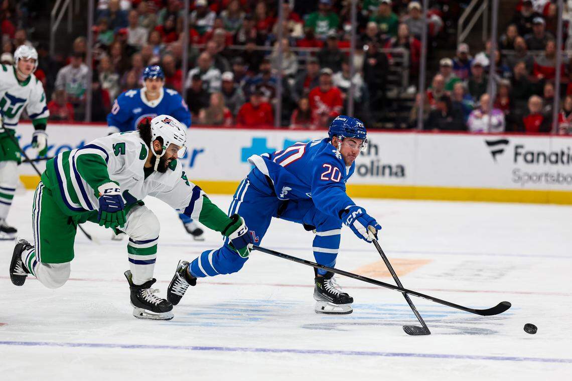 Ross Colton (20) of the Colorado Avalanche and Jalen Chatfield (5) of the Carolina Hurricanes fight for the puck during the first period at Lenovo Center on Jan. 3, 2026 in Raleigh, North Carolina.