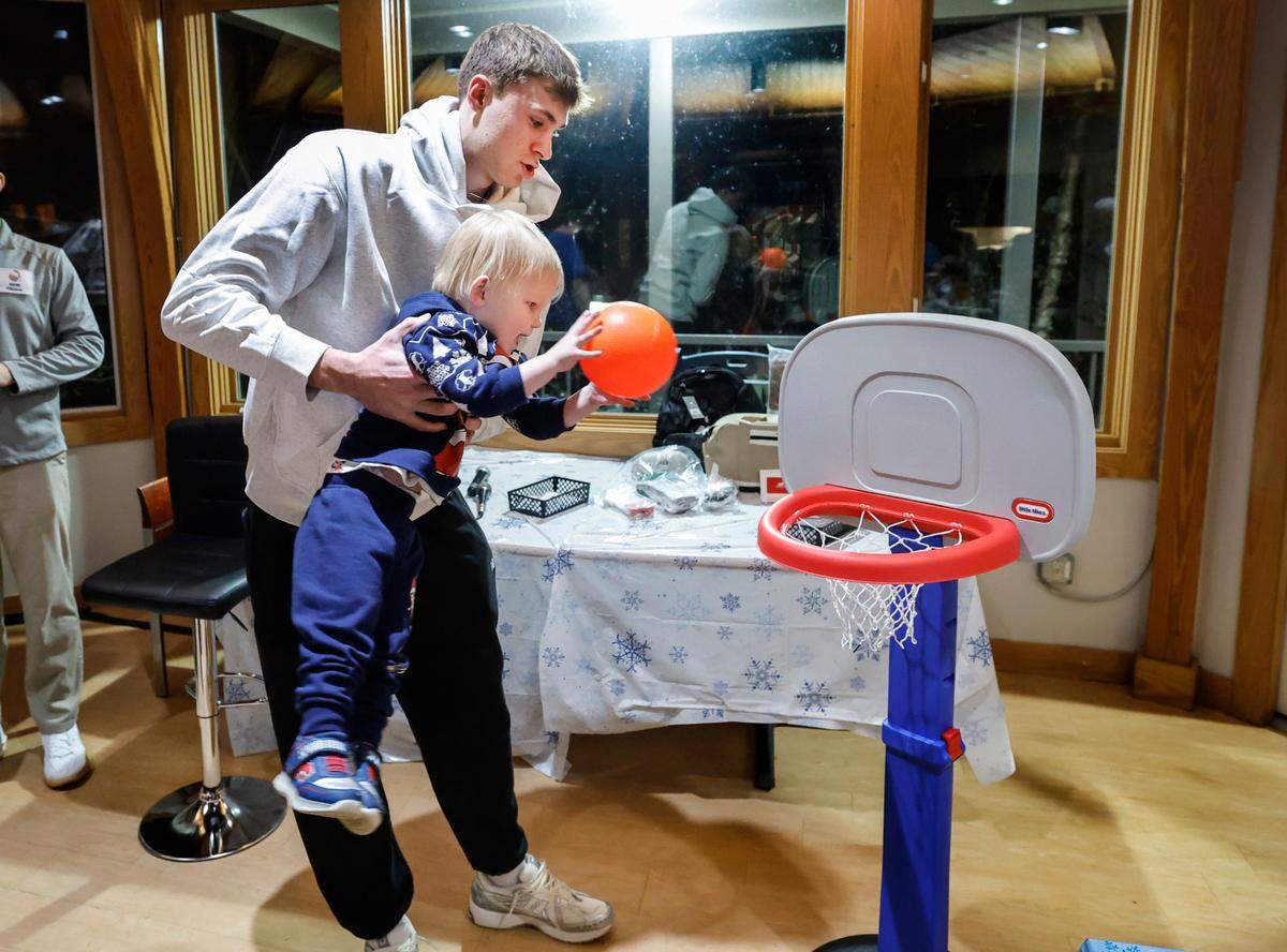 Cooper Flagg helps three-year-old Eli slam in two during a gathering at the Ronald McDonald House Charities of the Triangle in Durham, N.C., Thursday, Dec. 12, 2024. Eli and his family were at the house before Eli was scheduled to have open heart surgery.
