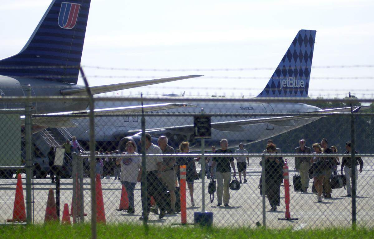 Airline passengers file off of a Jet Blue flight outside Terminal A Tuesday morning, Sept. 11, 2001, after the FAA grounded all flights in the United States. The carrier does not normally land at RDU.