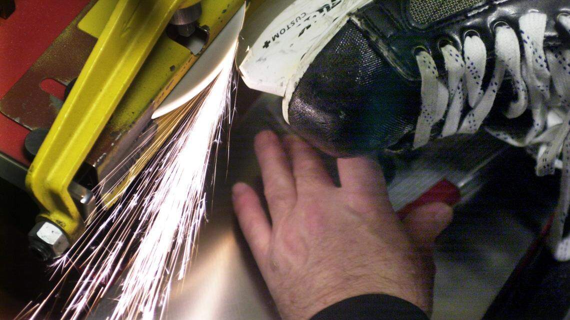 Former Carolina Hurricanes equipment manager Wally Tatomir sharpens a skate before a game.